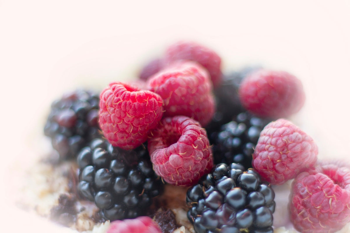 a bunch of raspberries and blackberries on top of oatmeal